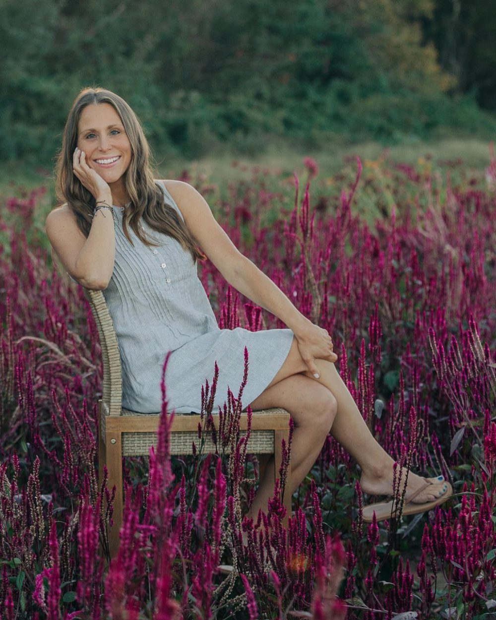 Alison, registered nurse and certified holistic nutrition coach, sitting in a field of flowers
